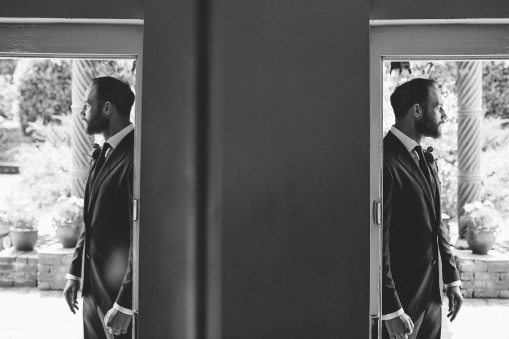 alternative wedding photo of groom in doorway